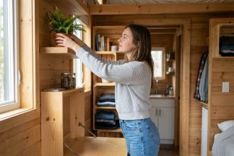 Jeune femme arrangeant des plantes dans un studio compact